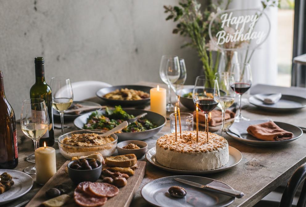 Table de fête de famille avec plats à partager et gâteau d'anniversaire